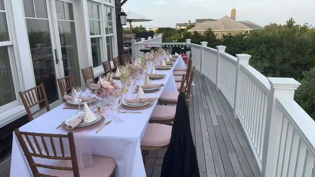 Long elegant dinner table on a deck ready for a private hibachi party