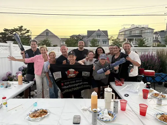 Guests having fun with the chef at a sunset backyard hibachi party