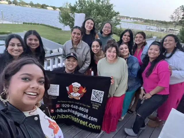 Group selfie on a waterfront deck at a hibachi catering event